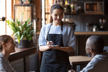 Waitress taking order of customers with a smile