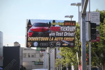 Outdoor LED billboard promoting auto show with car brands and free test drive offer in an urban dealership district in Los Angeles, CA