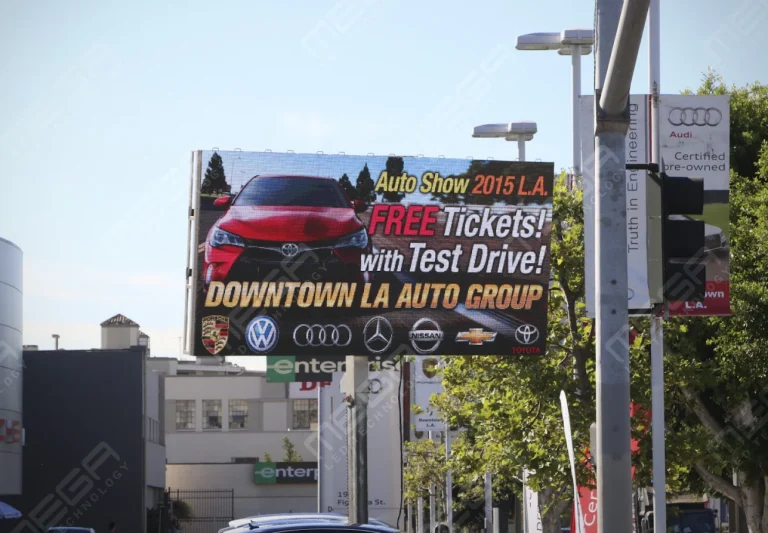 Outdoor LED billboard promoting auto show with car brands and free test drive offer in an urban dealership district in Los Angeles, CA
