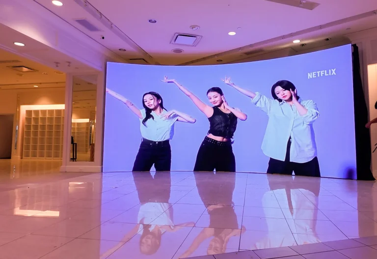 Large curved LED video wall displaying dancers in a modern indoor retail or exhibition space for immersive digital signage in Los Angeles, California