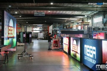 Large commercial LED display screens being assembled and tested inside a digital signage manufacturing facility.