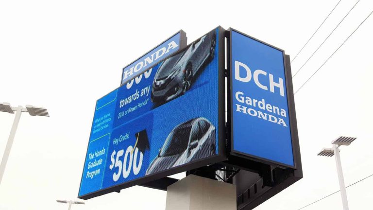 Outdoor double-sided LED digital billboard displaying Honda dealership advertisements on a roadside pylon sign.